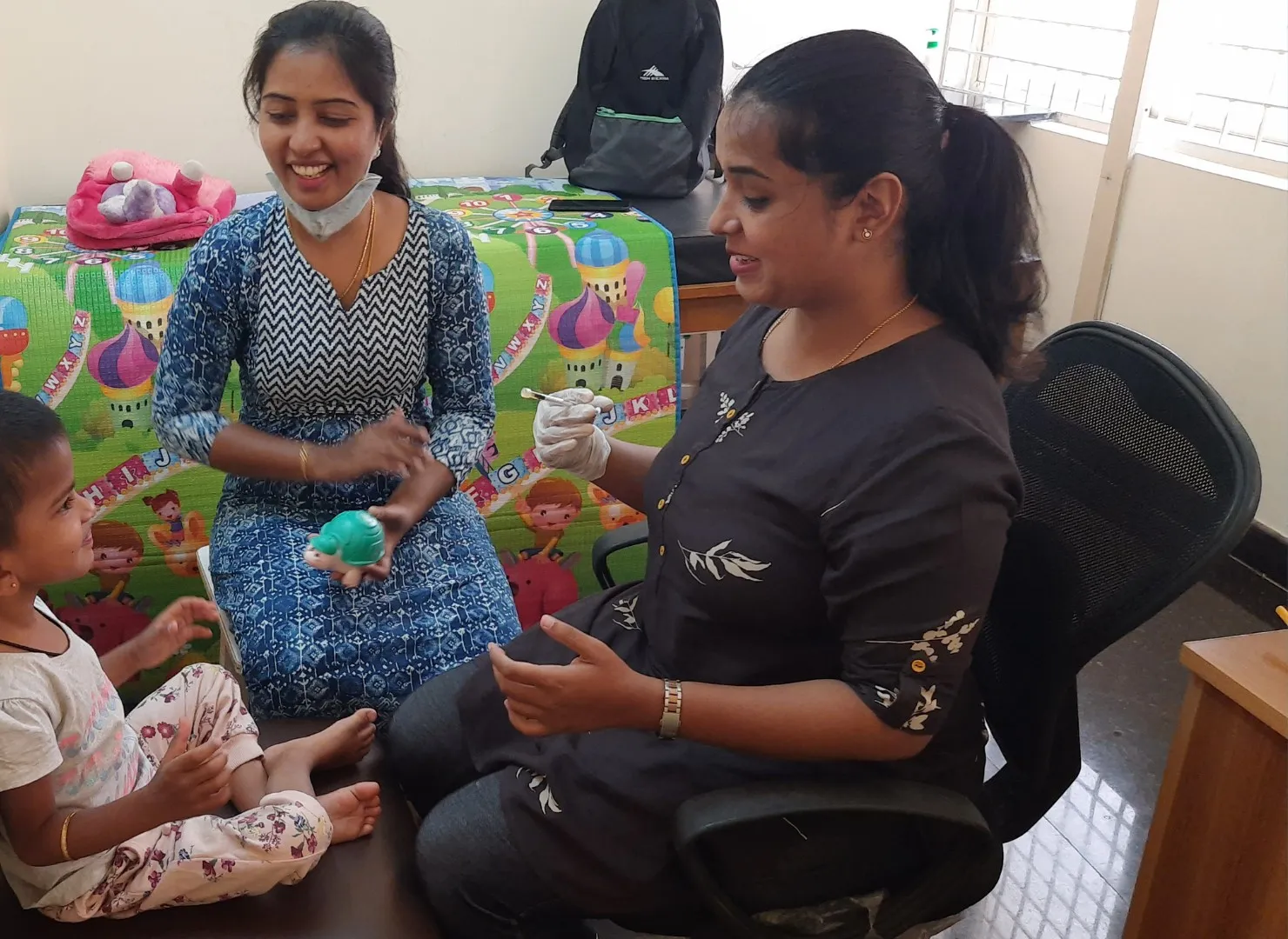 A therapist and parent working together with a toddler